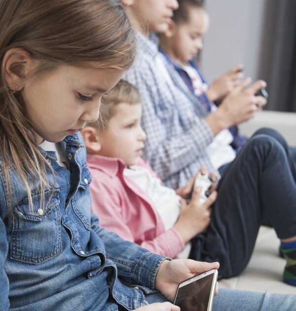 girl_browsing_smartphone_near_brothers_sister